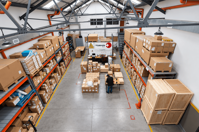 Depósito de Toshin con mercadería palletizada en racks, vista aérea